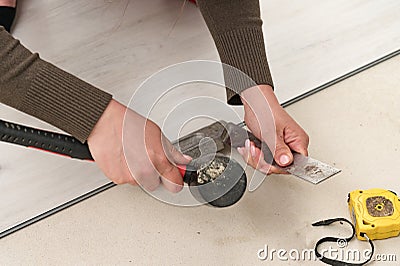 Woman installs quartz vinyl flooring, installing quartz vinyl flooring on a flat surface. Stock Photo