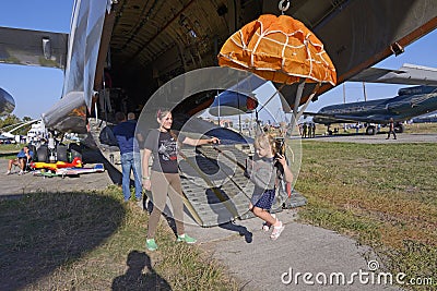 woman instructor teaching little girl how to handle parachute using flying landing simulator, airshow. Kyiv, Ukraine Editorial Stock Photo