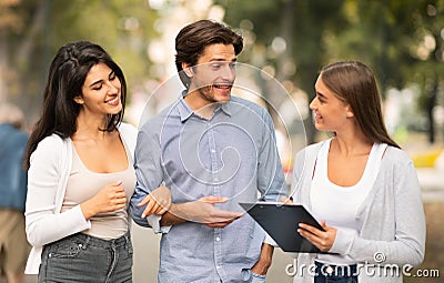 Woman Interviewing Couple Conducting Opinion Poll Walking In City Outdoor. Stock Photo