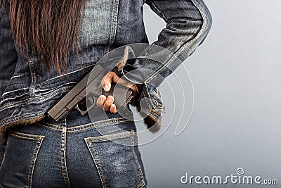 Woman in jeans is holding a gun Stock Photo