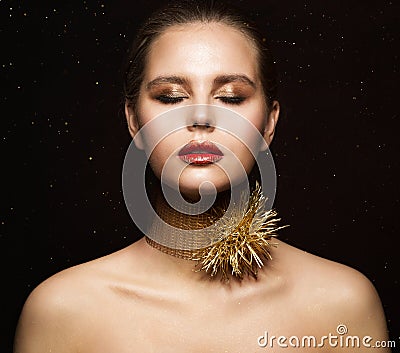 Woman Jewelry Necklace. Fashion Girl in Gold Collar with Thorns. Eyes closed Model in golden Makeup. Black Background Stock Photo