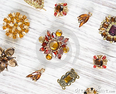 Woman Jewelry. Vintage jewelry background. Beautiful bright rhinestone brooch and earrings on white wood. Flat lay, top view Stock Photo