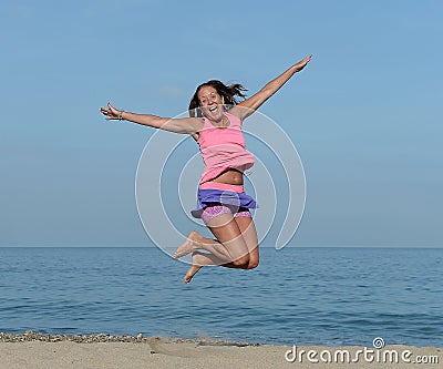 Woman jumping on beach Stock Photo