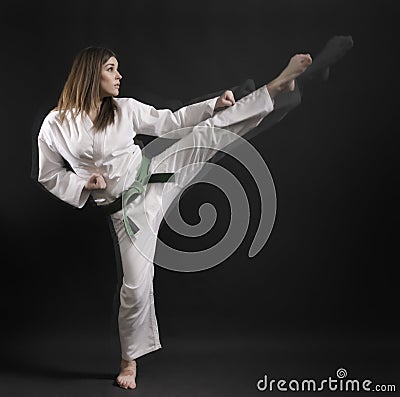 Woman of karate performs a high kick- 01. Stock Photo