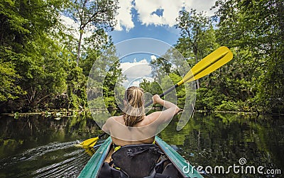 Woman Kayaking down a beautiful tropical jungle river Stock Photo