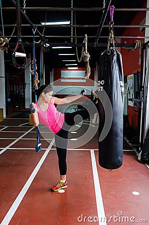 Woman kicking a punching bag Stock Photo