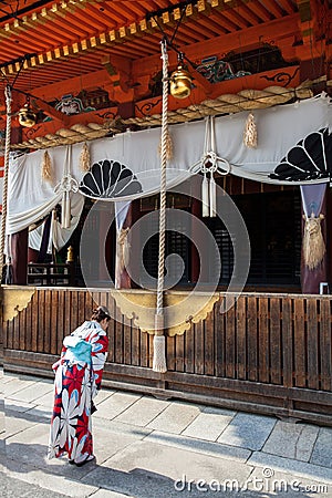 A woman in a Kimono makes an offering at a temple in Asakusa, Tokyo Japan Editorial Stock Photo