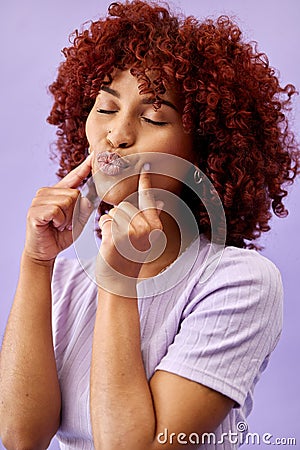 Woman, kiss face and beauty, hair and red curls with skin, playful and young isolated on purple background. Pout Stock Photo
