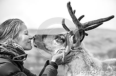 Woman kissing a cute reindeer. Stock Photo