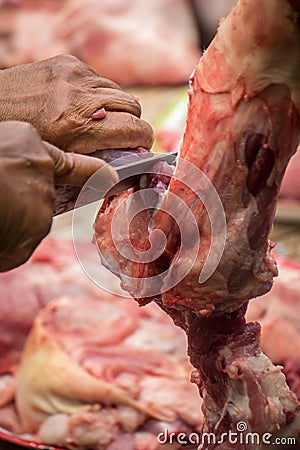 Woman in the kitchen cooking roast pork: cutting meat. Stock Photo