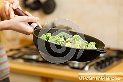 Woman cooking stir fry frozen vegetable on pan Stock Photo