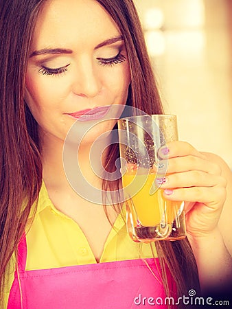 Woman in kitchen drinking fresh orange juice Stock Photo