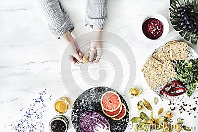 Woman in the kitchen and her healthy food eating selection: fruits, vegetables, super food, seeds, marble background copy space. Stock Photo
