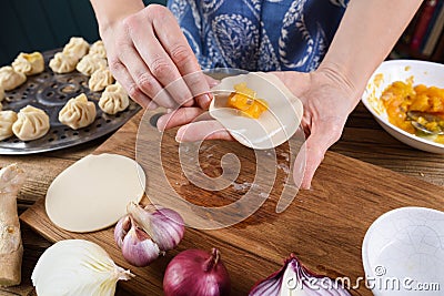 Woman in kitchen. Making traditional Asian steam dumplings with Stock Photo