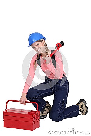 Woman kneeling by tool box Stock Photo