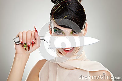 Woman with a knife over her face Stock Photo