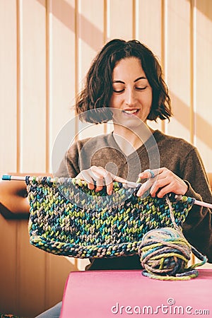 A woman knits from thick yarn Stock Photo