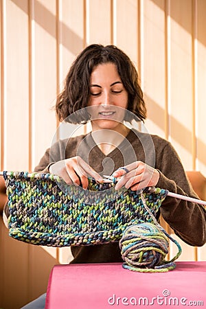 A woman knits from thick yarn Stock Photo