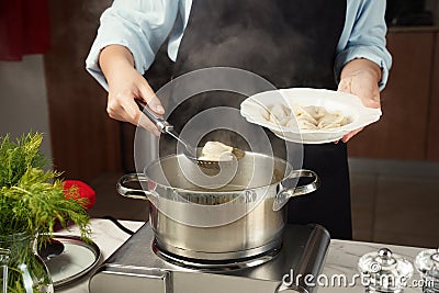 Woman with a ladle full of boiled dumplings. Stock Photo