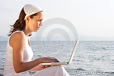 Woman with laptop on beach Stock Photo