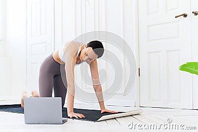 Woman with laptop computer at yoga studio. Fitness, technology and healthy lifestyle concept Stock Photo