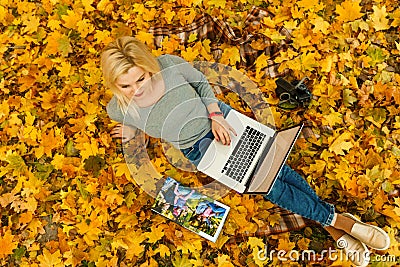 woman with laptop and photo book in autumn park Editorial Stock Photo