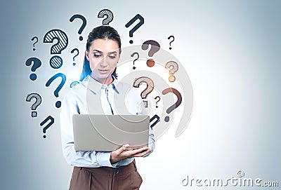 Woman with laptop, question marks Stock Photo