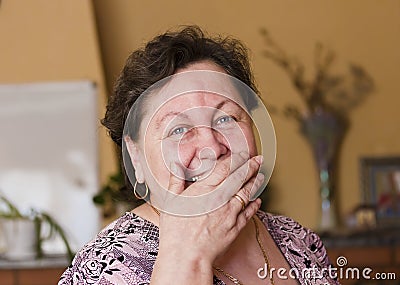 The woman laughs,covering her mouth with her hand Stock Photo