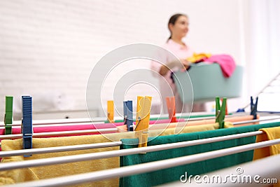 Woman with laundry basket indoors, focus on drying rack. space for text Stock Photo