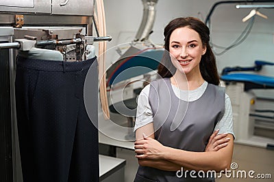 Woman laundry office worker smiling standing near automatic ironing mannequin Stock Photo