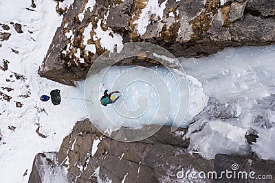 Woman is leading on Ice. Ice Climbing on Frozen Waterfall, Drone Shot. Barskoon Valley, Kyrgyzstan Stock Photo