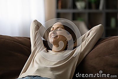 Woman lean on sofa closing eyes breath fresh conditioned air Stock Photo