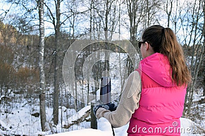 Woman leaning to snowy fence Stock Photo