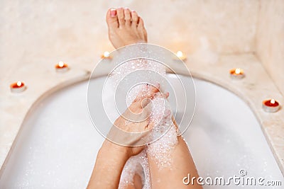 Woman legs in bath foam. Relaxation in spa Stock Photo