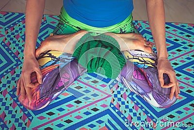 Woman legs in colorful leggings in lotus pose from above view in Stock Photo