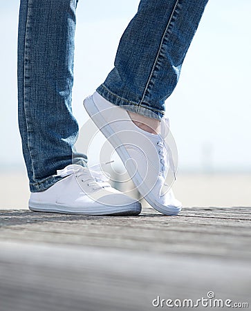 Woman legs in comfortable white shoes standing outdoors Stock Photo