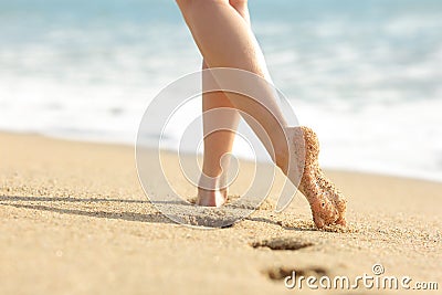 Woman legs and feet walking on the sand of the beach Stock Photo