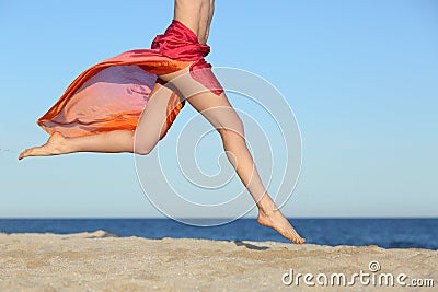 Woman legs jumping on the beach happy Stock Photo