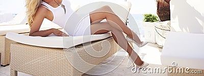 Woman legs on a sun lounger. Stock Photo
