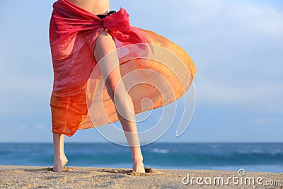 Woman legs on vacations posing on the beach with a pareo Stock Photo