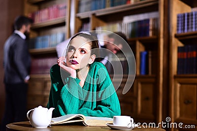 Woman in library read book at teapot drinking coffee from cup. literature cafe with cute girl and men. student life in Stock Photo