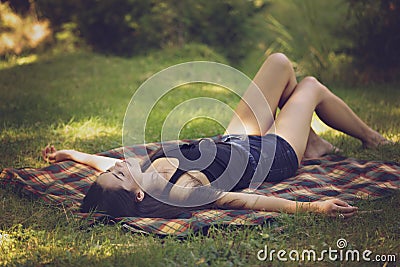 woman lies on a blanket and relax in nature Stock Photo