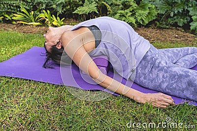 Woman lies on a yoga block to improving posture Stock Photo