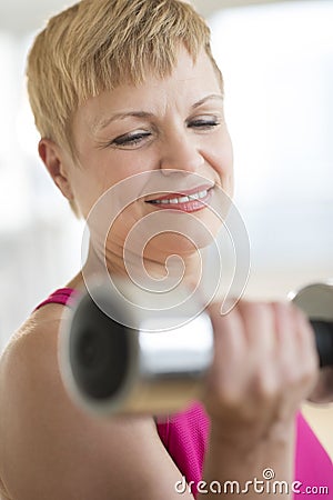 Woman Lifting Weights At Health Club Stock Photo