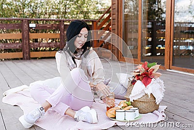 woman in light clothes and white sneakers sits on a plaid Stock Photo