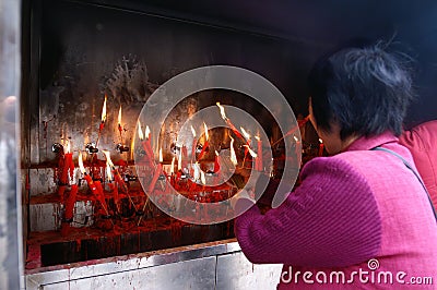 Woman light up her incense with candles Editorial Stock Photo