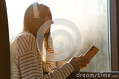 Woman listening to audiobook at table Stock Photo