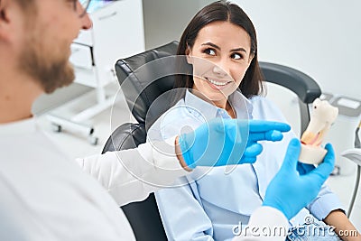 Woman listening to how dentist will treat root canals in her teeth Stock Photo