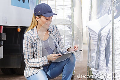 Woman listing clean laundry to be deliver Stock Photo