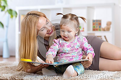 Woman and little girl watching a baby booklet Stock Photo